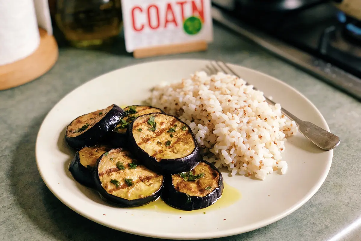Assiette avec des rondelles d'aubergine grillées et du riz, photo prise en intérieur sur table.